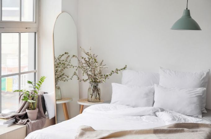 bedroom with bed, mattress, pillows and plants