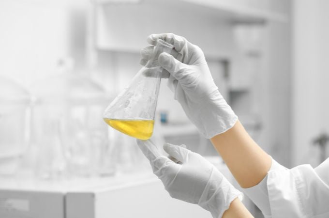 woman holding beaker of chemicals in a lab