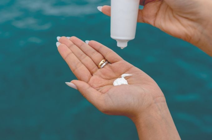 sunscreen being squirted into a woman's hand